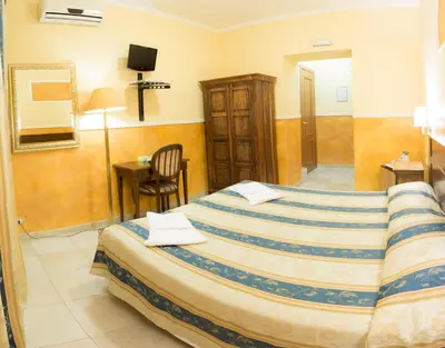a hotel room with a bed and a chair at Residenza Ki in Rome