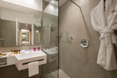 a hotel with a swimming pool with chairs and umbrellas at Crowne Plaza Rome St. Peter's by IHG in Rome