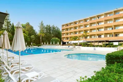 a hotel with a swimming pool with chairs and umbrellas at Crowne Plaza Rome St. Peter's by IHG in Rome