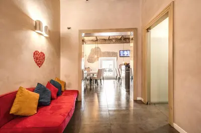 a living room with a red couch with pillows at Roma Boutique Hotel in Rome