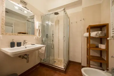 a bathroom with a sink and a glass shower at Saint Peter Apartment in Rome