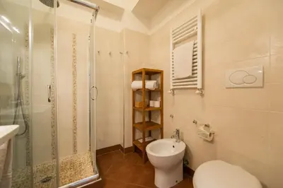 a bathroom with a toilet and a glass shower at Saint Peter Apartment in Rome