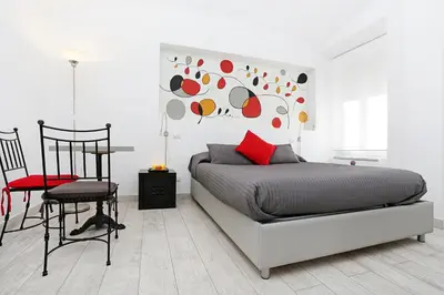 a bedroom with a bed and a red pillow and a chair at Houspitality Nero Bed & Breakfast in Rome