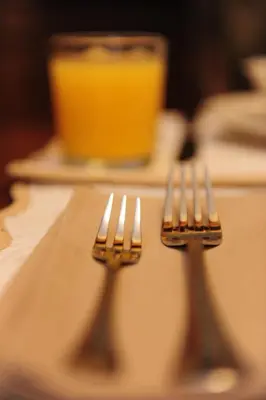 two silver forks sitting on a table with a drink at Houspitality Nero Bed & Breakfast in Rome