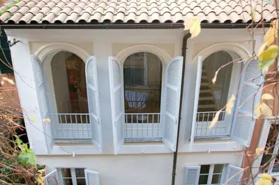 a white house with white shutters on the windows at Casa Fabbrini Boutique B&B in Rome