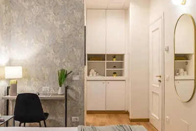 a bedroom with a desk and a chair and a mirror at 94Rooms Vatican Guest House- Scipioni in Rome