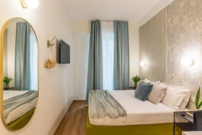 a hotel room with a bed and a mirror at 94Rooms Vatican Guest House- Scipioni in Rome