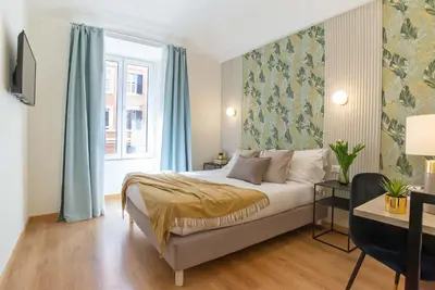 a bedroom with a bed with blue curtains and a window at 94Rooms Vatican Guest House- Scipioni in Rome