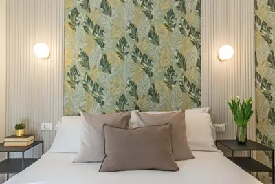 a bedroom with a bed with a floral wallpaper at 94Rooms Vatican Guest House- Scipioni in Rome