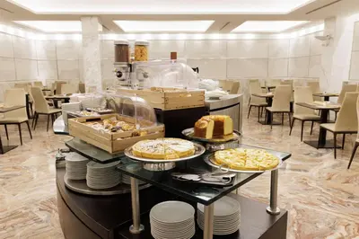a buffet line with cakes and pastries in a restaurant at Best Western Plus Hotel Universo in Rome