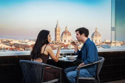 a man and woman sitting at a table drinking wine at Best Western Plus Hotel Universo in Rome