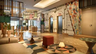 a lobby with chairs and tables in a building at Hilton Garden Inn Rome Colosseum in Rome