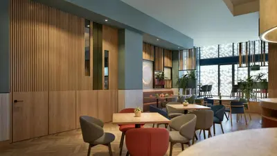 a restaurant with tables and chairs in a room at Hilton Garden Inn Rome Colosseum in Rome