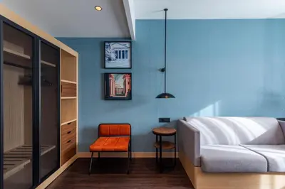 a bedroom with a bed and a chair and a stool at Hilton Garden Inn Rome Colosseum in Rome