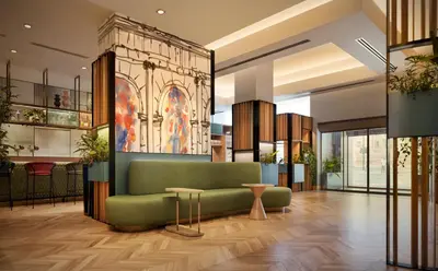 a lobby with a green couch and a table at Hilton Garden Inn Rome Colosseum in Rome