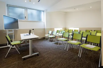 a conference room with chairs and a flat screen tv at Best Western Premier Hotel Royal Santina in Rome