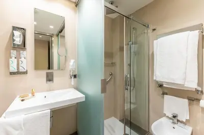 a bathroom with a sink and a glass shower at Best Western Premier Hotel Royal Santina in Rome