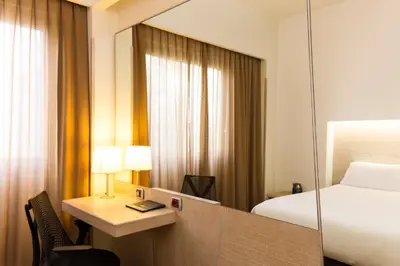 a hotel room with a bed and a mirror at Hilton Garden Inn Rome Claridge in Rome