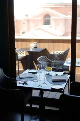 a table with plates and glasses on a balcony at Radisson Blu GHR Rome in Rome