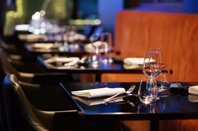 a row of tables with wine glasses and napkins at Radisson Blu GHR Rome in Rome