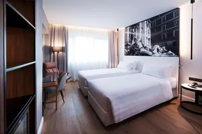 a hotel room with a white bed and a desk at Radisson Blu GHR Rome in Rome