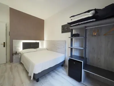 a bedroom with a bed and a book shelf at Hotel Osimar in Rome