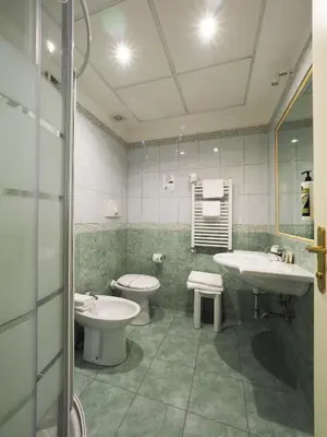 a bathroom with two sinks and two toilets in it at Hotel Osimar in Rome