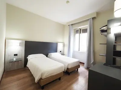 a hotel room with two beds and a window at Hotel Osimar in Rome