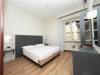 a bedroom with a white bed and a window at Hotel Osimar in Rome