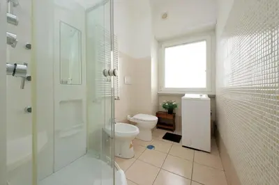 a bathroom with a toilet and a shower and a window at 4BNB - Cipro Vatican Apartment in Rome