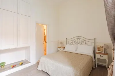 a white bedroom with a bed and a window at Dante's in Vaticano in Rome