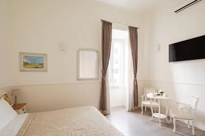 a bedroom with a bed and a table with chairs at Dante's in Vaticano in Rome