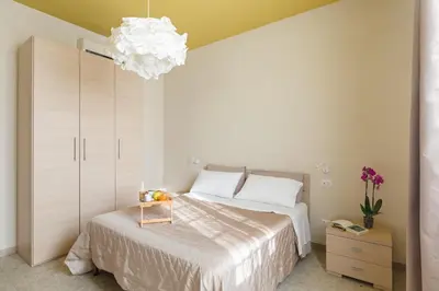 a bedroom with a large bed and a chandelier at B&B L'Amaca in Rome