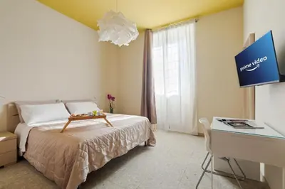 a bedroom with a bed and a desk and a tv at B&B L'Amaca in Rome