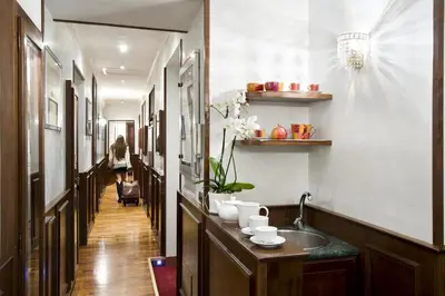 a hallway with a sink and a hallway with a woman walking down it at Al Viminale Hill Inn & Hotel in Rome