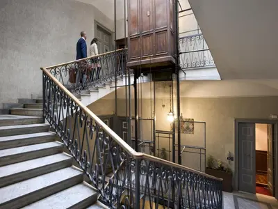 two people walking down the stairs of a building at Al Viminale Hill Inn & Hotel in Rome