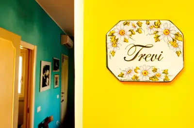 a clock on a yellow wall with flowers on it at Passeggiate Romane in Rome
