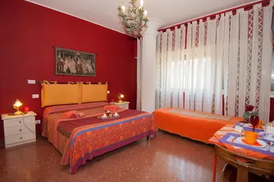 two beds in a room with red walls at Passeggiate Romane in Rome