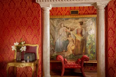a painting on the wall in a room with a chair at Residenza Canova Tadolini - Guesthouse in Rome