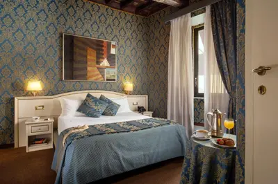 a bedroom with a bed in a room with blue wallpaper at Residenza Canova Tadolini - Guesthouse in Rome