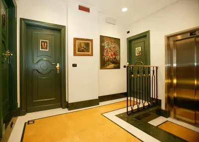 a hallway with two green doors and a staircase at Hotel Gregoriana in Rome
