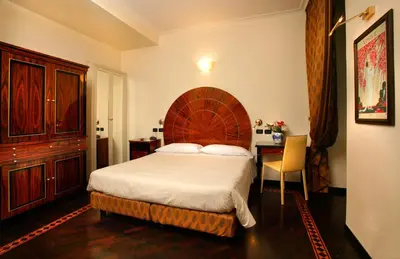 a bedroom with a large bed and a desk at Hotel Gregoriana in Rome