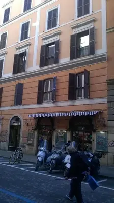 a person walking in front of a building with motorcycles at B&B&Courtesy in Rome