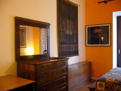 a bedroom with a dresser and a mirror on the wall at B&B&Courtesy in Rome