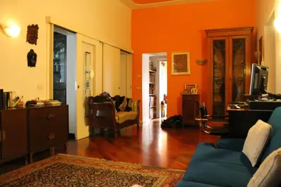 a living room with orange walls and a blue couch at B&B&Courtesy in Rome
