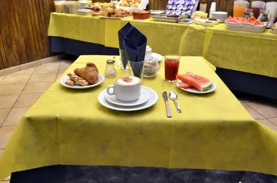 a table with plates of food and a cup of coffee at Hotel Tex in Rome