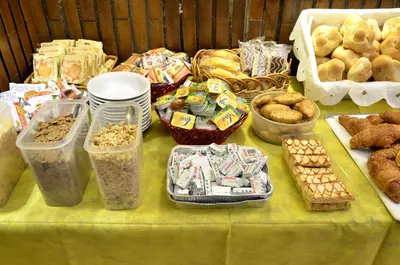 a table with a green table cloth with pastries and food at Hotel Tex in Rome