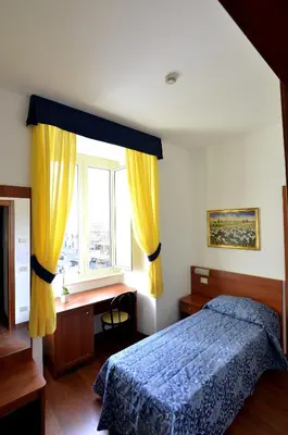 a bedroom with a bed and a desk and a window at Hotel Tex in Rome