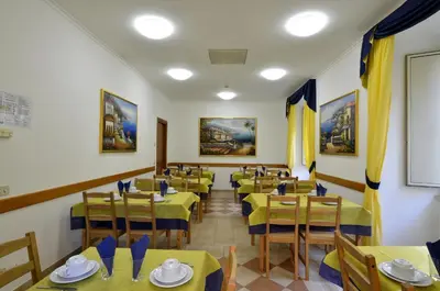 a restaurant with tables and chairs with yellow tablecloths at Hotel Tex in Rome