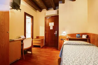 a bedroom with a bed and a desk and a desk at Hotel Corot in Rome